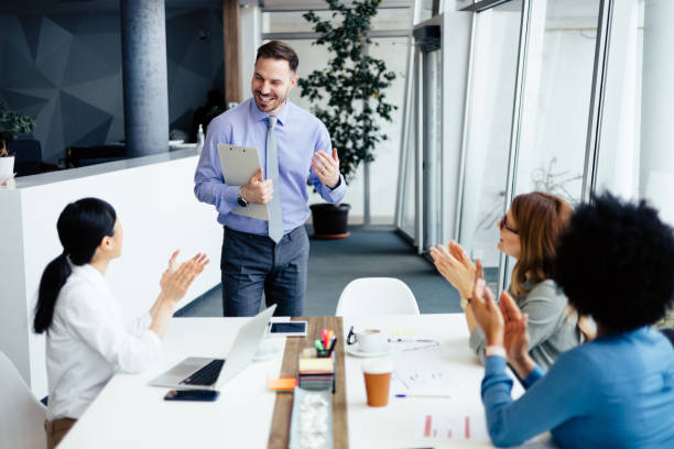 istock Cheerful business team clapping in an office 2112305092