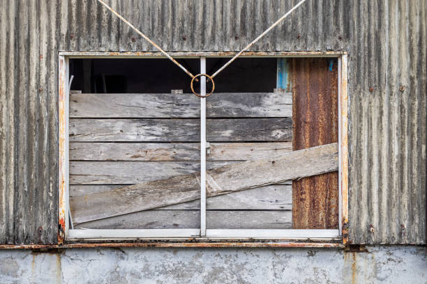 Wall of an old warehouse clad with corrugated asbestos cement sheets and with repairs of corrugated and rusty metal sheets the city of Sabang which in the main city on the island Weh north of Sumatra