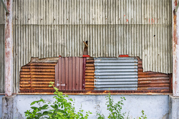 Wall of an old warehouse clad with corrugated asbestos cement sheets and with repairs of corrugated and rusty metal sheets the city of Sabang which in the main city on the island Weh north of Sumatra