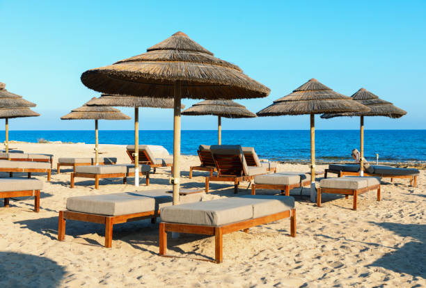 istock Sunbeds and umbrellas on a sandy beach 2112363659