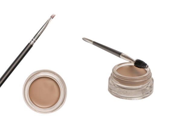 A brow pomade in blonde shade with brush isolated on a white background. Make up.