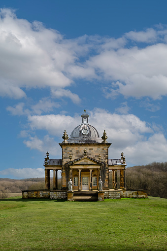 Castle Howard, York, UK - March 23, 2024.  A vertical panoramic landscape of The Temple Of The Four Winds in the gardens of the British Stately Home of Castle Howard on a bright sunny day with copy space