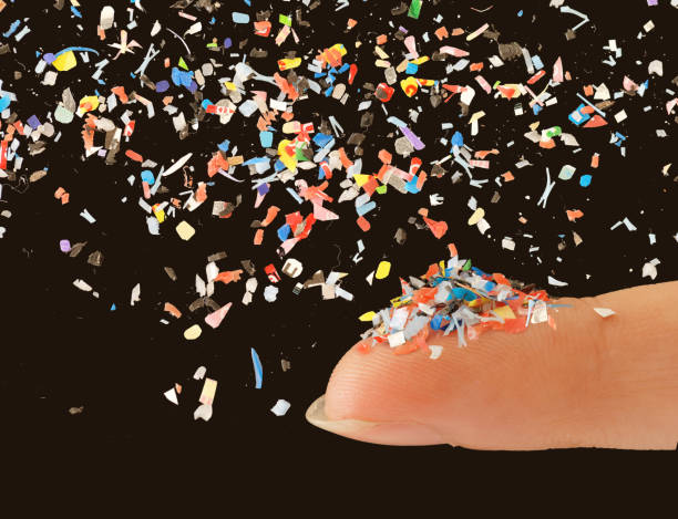 Close up of microplastic on female finger concept of water plastic pollution and global warming Close up of microplastic on finger concept of water pollution and global warming microplastic stock pictures, royalty-free photos & images