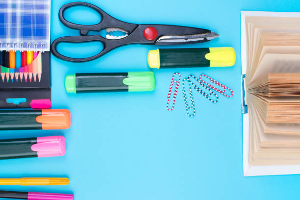 istock Back to school. Stationery on a blue table. Office desk with copy space. Flat lay. 2112459945