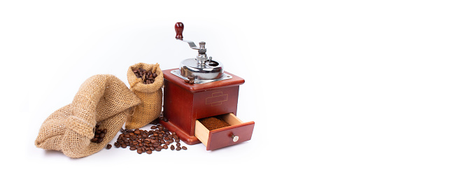 Pile of coffee beans, coffee grinder, ground coffee on a white background. Top view. Banner