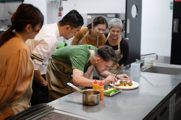 A Male Student Demonstrates Food Decoration Techniques during a Cooking Class in Curriculum Education Training for Meals and Food Preparation.