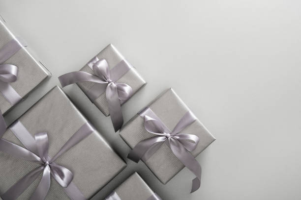 istock Monochrome gray gift boxes with gray ribbons on light background. Place for your text. 2112485441