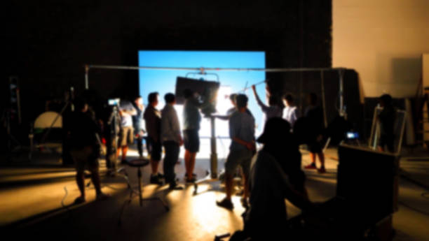 istock Blurry images of making video production shooting studio in silhouette which have professional equipment such as camera, tripod and blue screen backdrop set for chroma key technique in post process 2112491171
