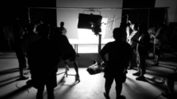 istock Blurry images of making video production shooting studio in silhouette which have professional equipment such as camera, tripod and blue screen backdrop set for chroma key technique in post process 2112491174