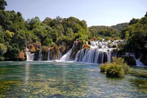 A Waterfall cascading in lush forest with rocks and trees