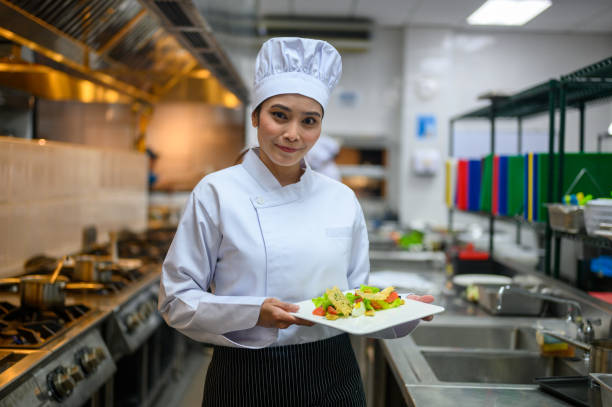 kulinarny triumf: dumna azjatycka studentka prezentuje swoje pyszne kreacje po ukończeniu profesjonalnej szkoły gotowania - czeladnik zdjęcia i obrazy z banku zdjęć