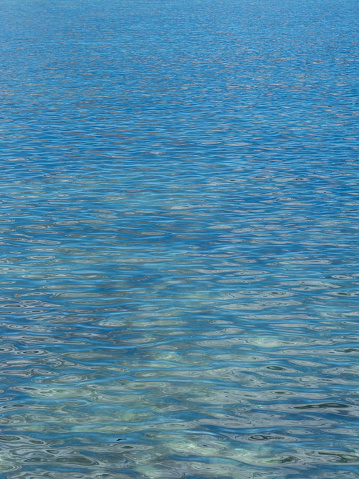 Beautiful water surface with light reflections off the Seychelles island of Praslin in blue and turquoise tones