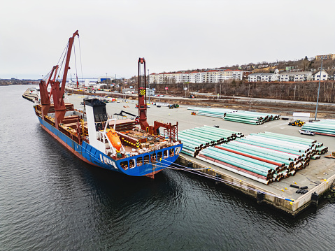 Aerial view of decommissioned pipeline being loaded onto a cargo ship.