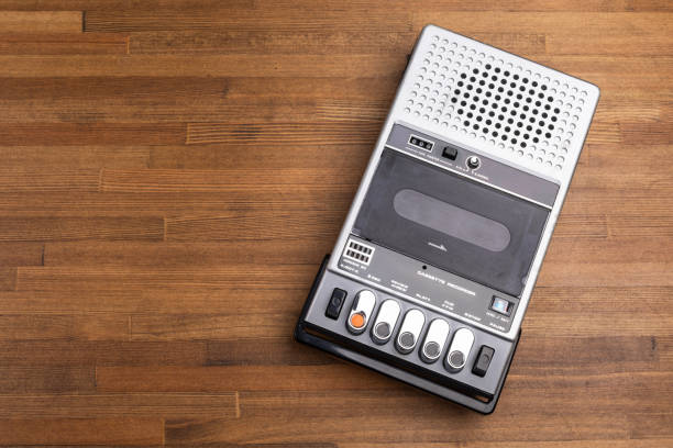 VIntage portable tape recorder with built-in speaker, microphone and simple control buttons on a rustic wooden table