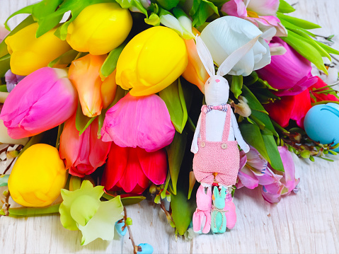 Beautiful Easter bunnie with flowers, as a decoration for the Easter holiday. High quality photo