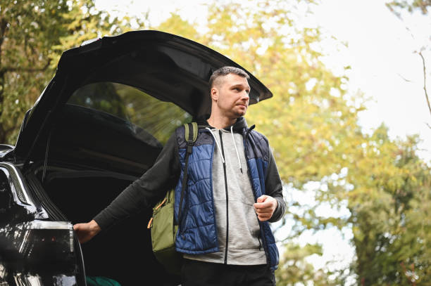 istock Traveler closing car trunk. 2112561935