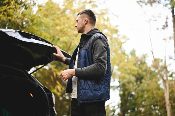 istock Portrait of a man closing car trunk. 2112562447
