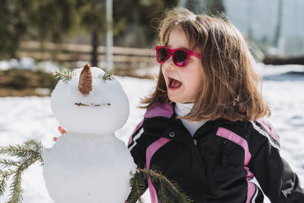 istock girl playing in the snow 2112570269