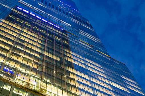 Low angle view of modern office buildings at night, New York City, USA