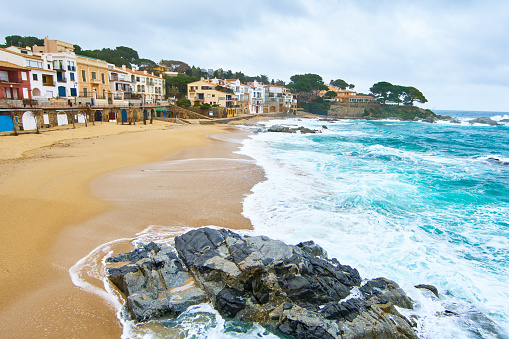 Calella de Palafrugell in Costa Brava, Catalonia. \n\nGrey day with huge waves in the mediterranean sea. \n\nAmazingly beautiful tiny coastal village in Catalonia.