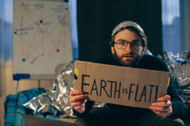 istock Championing Pseudoscience: Man Holding 'The Earth is Flat' Sign 2112602101