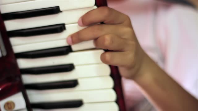 Young Boy Playing An Old Red Piano Accordion. Close Up.