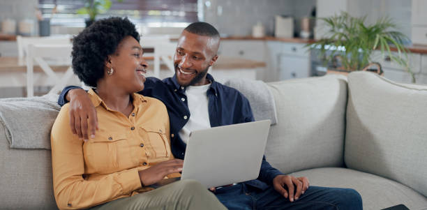 istock Young black couple using laptop sitting on the floor at home. 2112618179