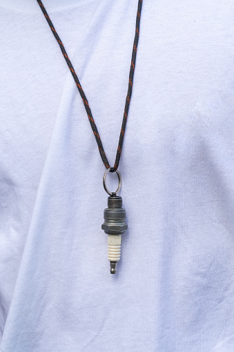 A necklace made of spark plugs strung on a strap