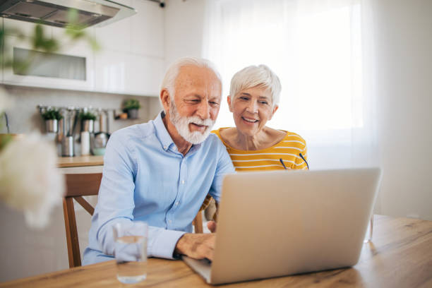 istock Shot of an affection senior couple using their laptop while relaxing at home 2112653482