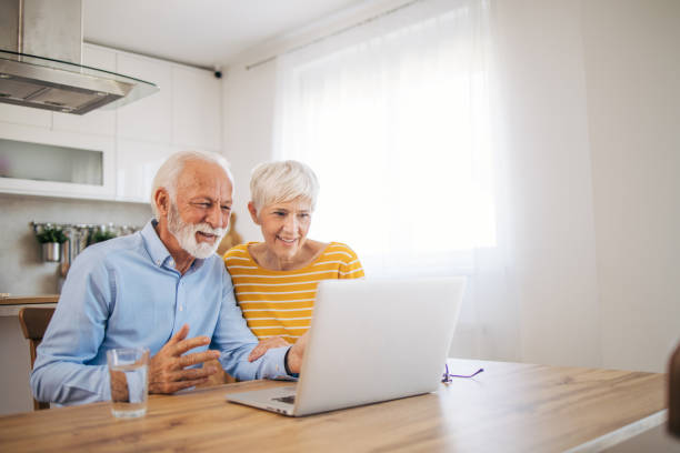 istock Shot of an affection senior couple using their laptop while relaxing at home 2112658583