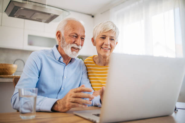 istock Shot of an affection senior couple using their laptop while relaxing at home 2112659619