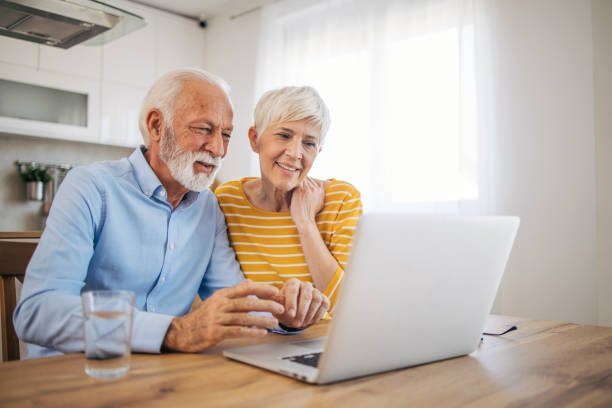 istock Shot of an affection senior couple using their laptop while relaxing at home 2112659620