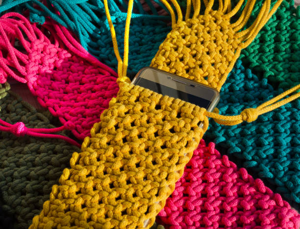 istock Multi-colored bags for mobile phones on a wooden background. 2112665305
