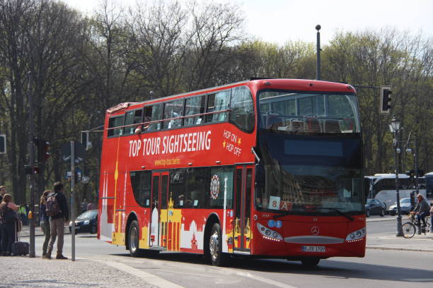 Berlin, Germany – April 04, 2019: Red double decker bus on road with pedestrians on sidewalk