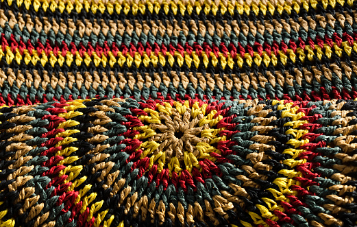 Beautiful pattern. Close-up of raffia crochet. Handmade knitted raffia jewelry.