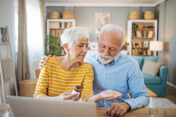 istock Seniors reading medicine bottle labels on laptop 2112673080