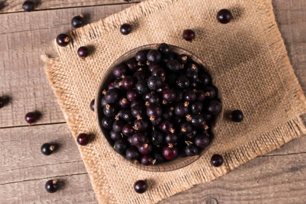 istock Black currant in a bowl on wooden background. Organic berries. 2112676229