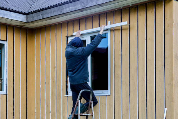istock Exterior finishing work on frame and panel house on facade side, roofer installs window opening jambs. 2112676762