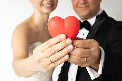 The bride and groom are holding heart.