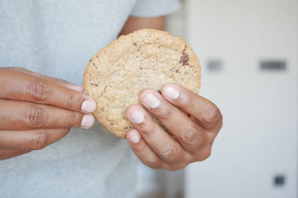 istock men hand breaking sweet cookies 2112744786