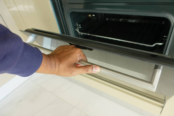 istock hand open electric oven door at home 2112754253