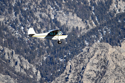 Single engine plane (Aronca 7AC) flying through the Lost River Mountains of East Central Idaho.