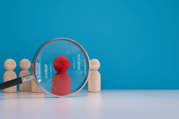 istock Human resources, magnifying glass with pawns 2112814958