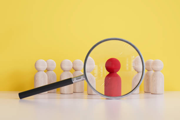 istock Human resources, magnifying glass with pawns 2112815983