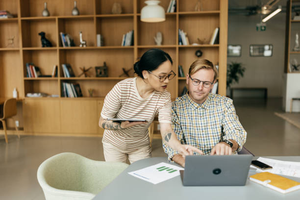 istock Two individuals collaborating on a business project in the office. 2112843502