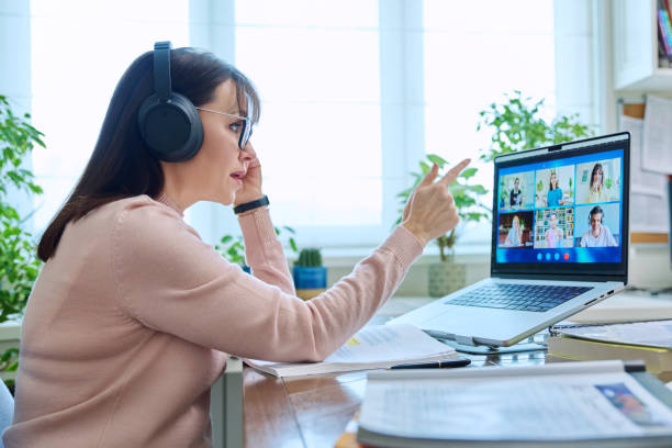istock Woman teacher in headphones teaching online, high school students on computer screen 2112866809