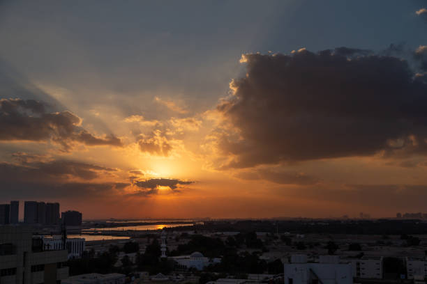 istock Beautiful vibrant orange sunrise sky with sun rays in Abu Dhabi 2112872284