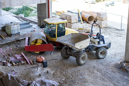 A Man in Bulldozer is Working at a Construction Yard.