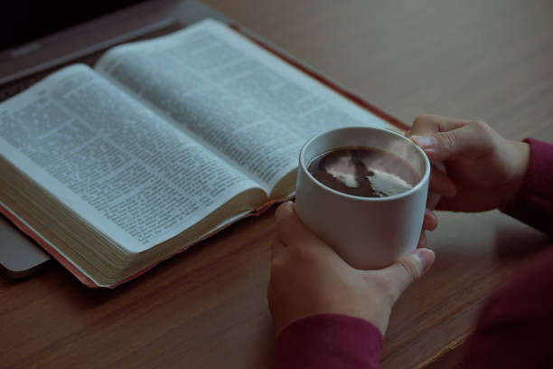 człowiek siedzący i modlący się o błogosławieństwo od boga z biblią złożonymi rękami w biblijnej, duchowej i religijnej modlitwie, komunikuj się, rozmawiaj z bogiem. miłość i przebaczenie, poranna biblia. - credo zdjęcia i obrazy z banku zdjęć