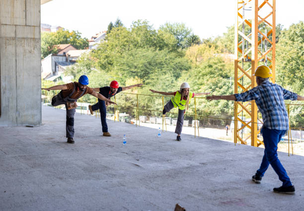 istock Four Workers of Different Ethnicities are Exercising at the Building Site. 2112890512
